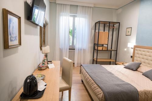 a bedroom with a bed and a desk and a television at Brunelli B&B in Assisi