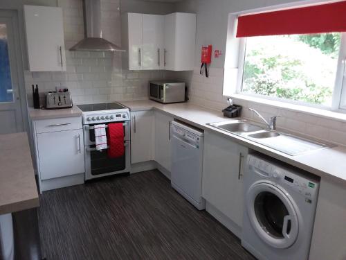 a kitchen with a sink and a stove and a dishwasher at Alderman Peel High School Bungalow in Wells next the Sea