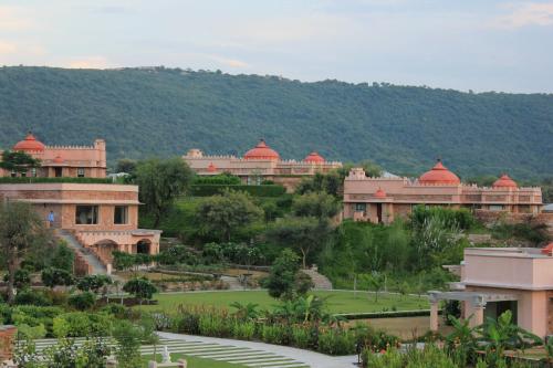 ジャイプールにあるTree of Life Resort & Spa Jaipurの公園内の赤いドームの建物群