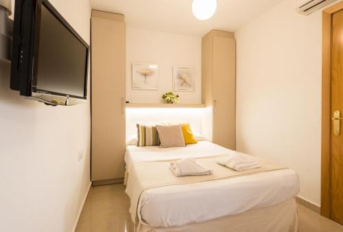 1 dormitorio con 1 cama y TV de pantalla plana en LU&CIA City Beach Puerto 1, en Málaga