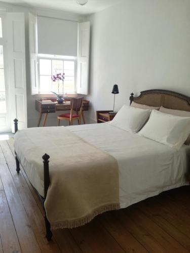 sypialnia z dużym białym łóżkiem i stołem w obiekcie Casa de Guadalupe w mieście Braga