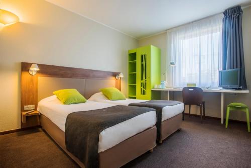 A bed or beds in a room at Campanile Wroclaw - Stare Miasto