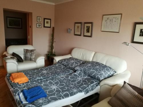- une chambre dotée d'un lit avec une couverture bleue et blanche dans l'établissement Zsolnay Apartman, à Pécs