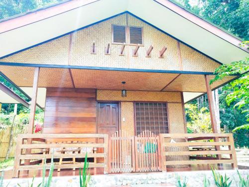a small house with a porch and wooden fences at Victordelia Hilltop Hostel in San Vicente