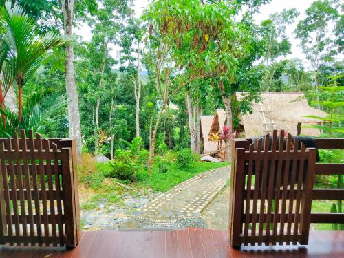 two chairs sitting on a porch looking out at a road at Victordelia Hilltop Hostel in San Vicente