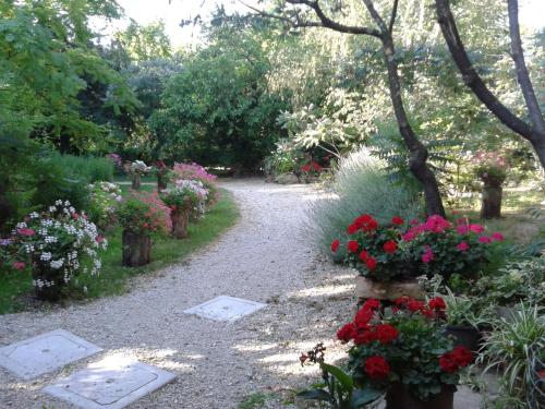 a garden with flowers on a gravel path at Bosco Romagno in Cividale del Friuli