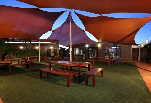 a group of tables and benches under a tent at Mia Mia House in the Desert in Newman