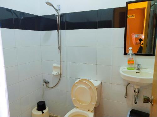 a bathroom with a shower and a toilet and a sink at Victordelia Hilltop Hostel in San Vicente