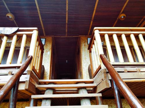 two wooden seats in a room with a ceiling at Victordelia Hilltop Hostel in San Vicente