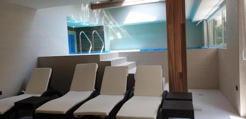 a waiting room with white chairs and a mirror at Baobab Suites in Siófok