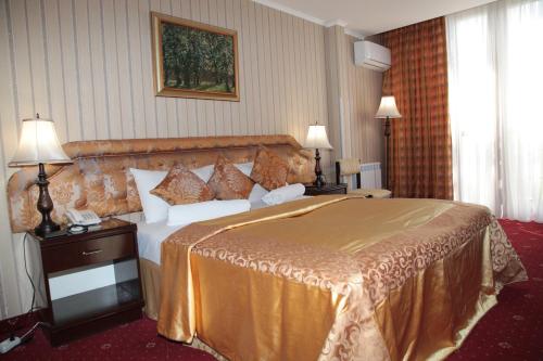 a hotel room with a large bed and two lamps at Shirak Hotel in Yerevan