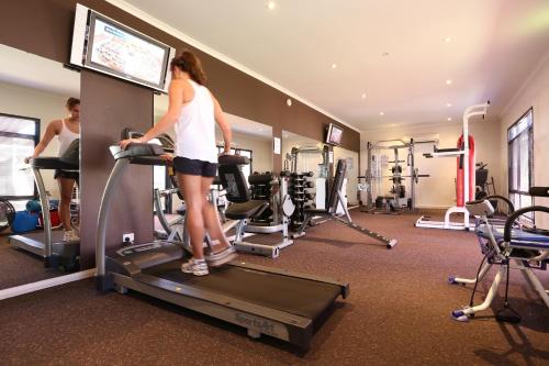 a woman standing on a treadmill in a gym at Mia Mia House in the Desert in Newman