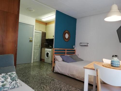 ein Schlafzimmer mit einem Bett und einem Tisch in einem Zimmer in der Unterkunft Estudio acogedor in Tarragona