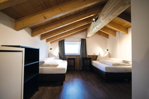 two beds in a room with wooden ceilings at Appartements Bergheim St Andrä bei Brixen in Bressanone
