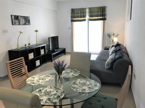 a living room with a couch and a glass table at Kyklades Resort & Spa in Paralimni