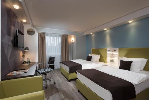 Habitación de hotel con 2 camas y escritorio en Best Western Hotel Peine Salzgitter, en Peine