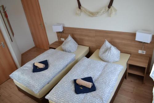 two beds with blue and white pillows in a room at Gasthof Keilbach in Sindelfingen