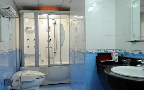 a bathroom with a shower and a toilet and a sink at Camela Hotel & Resort in Hai Phong