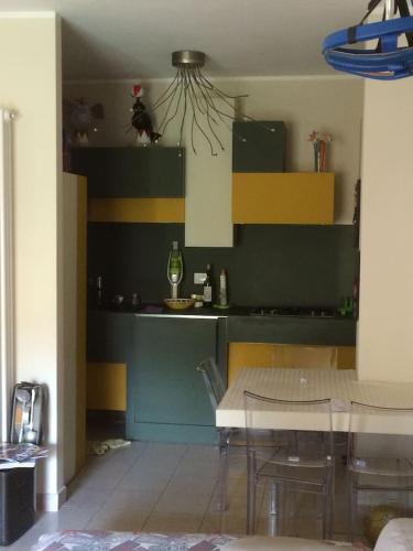 a dining room with a table and a kitchen at PIANO TERRA CON GIARDINO VICINO AL MARE in Viareggio