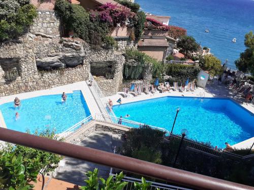 a large swimming pool with people in the water at Conca Verde c21- BEACH FRONT little villa- POOL, private JACUZZI sea view in Marina di Andora