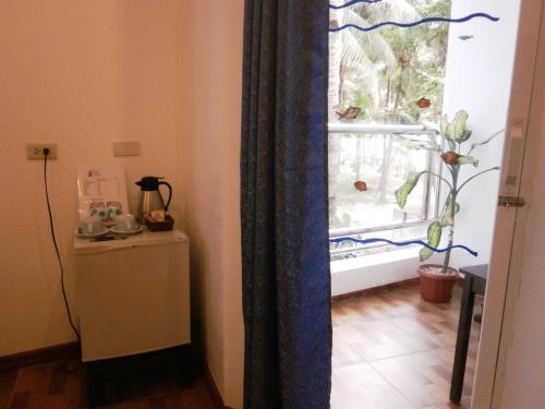 a room with a window and a table with a plant at DiveGurus Boracay Beach Resort in Boracay