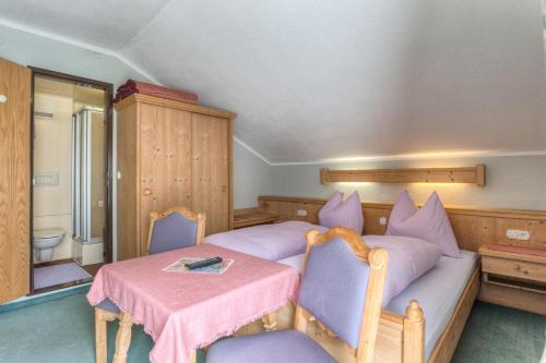 a bedroom with a bed and a table and chairs at Café Landerl in Matrei in Osttirol