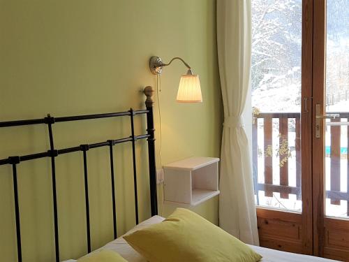 a bedroom with a bed and a lamp and a window at Chalet Solneige in Vaujany
