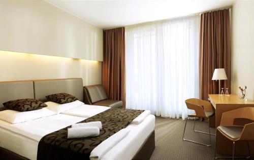 a hotel room with a bed and a desk at Hotel Thermana Park Laško**** Superior in Laško
