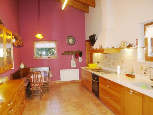cocina con paredes de color púrpura, mesa y sillas en Casa para familias en Prullans, en Prullans