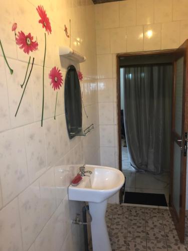 a bathroom with a sink and flowers on the wall at Villa contemporaine in Yaoundé