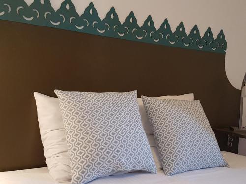 a bed with two pillows and a green headboard at Chalet Solneige in Vaujany