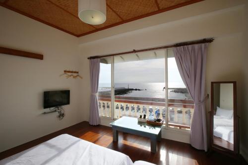 a bedroom with a large window with a view of the ocean at Mama Tian Homestay in Xiaoliuqiu