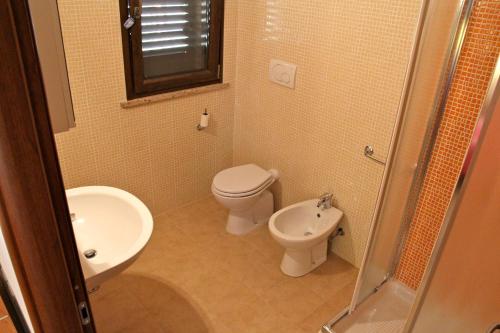 a bathroom with a toilet and a sink at Residence Le Casine in Batignano