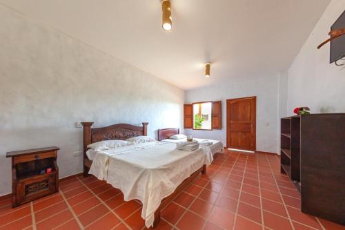 a bedroom with a bed and a dresser and a television at Casa de Teja Barichara in Barichara