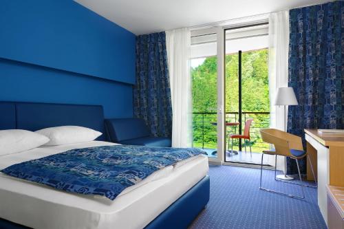 a hotel room with a bed and a window at Hotel Thermana Park Laško**** Superior in Laško