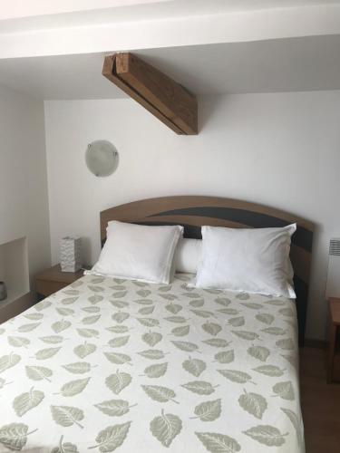 een slaapkamer met een groot bed met witte kussens bij Studio du couvent in Narbonne