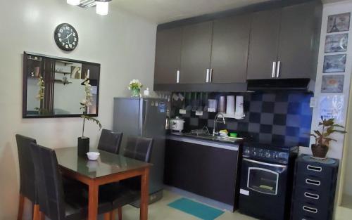 eine Küche mit einem Tisch, einem Herd und einer Spüle in der Unterkunft Jen's Apartment in Manila