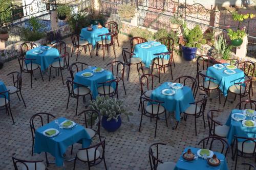 an empty patio with blue tables and chairs at Riad Selma in Meknès