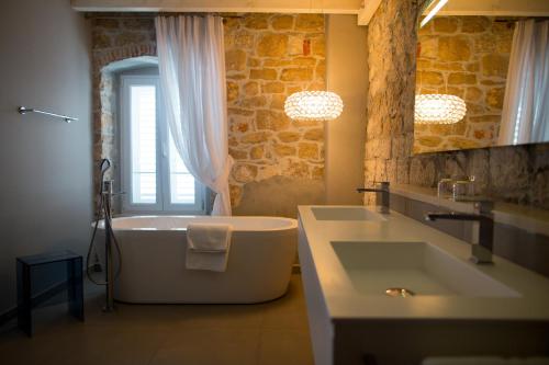 a bathroom with a large tub and a sink at Hotel Osam - Adults Only in Supetar