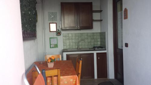 a small kitchen with a table and a sink at Salina Acroeoliano monolocali in villa in Leni