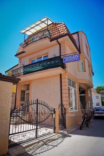 a building with a fence in front of it at Goldy Hostel in Bitola