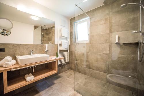 a bathroom with a sink and a shower at Vitaurina Royal Hotel in Molini di Tures