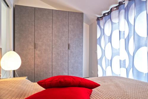 a bedroom with a bed with red pillows at Attico Mutti in Loano