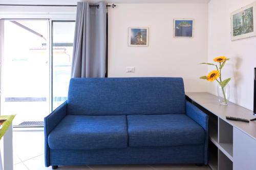 a blue couch in a room with a window at Attico Mutti in Loano