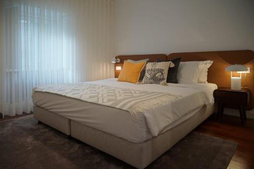 a bedroom with a large bed with pillows at Stay In Apartments - D. Hugo 23 in Porto