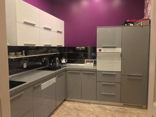 eine Küche mit weißen Schränken und lilafarbenen Wänden in der Unterkunft Luxury with sea view in Pula