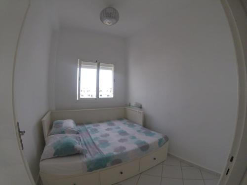 a small bedroom with a bed and a window at Duplex bord de mer - Arous Al Bahr in Tangier