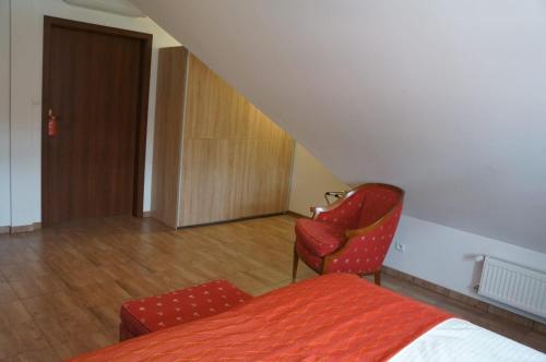 バルリネクにあるBukowa Przystań Barlinekのベッドルーム1室(ベッド1台、椅子1脚、ドア付)