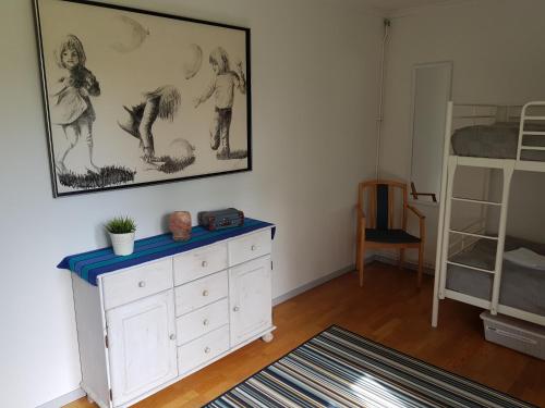 a bedroom with a white dresser and a bunk bed at Brukshotellet Skinnsberg in Skinnskatteberg