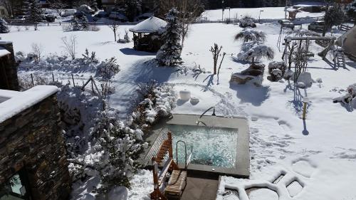 a snowy yard with a swimming pool in the snow at Hotel Gran Paradis in Campitello di Fassa